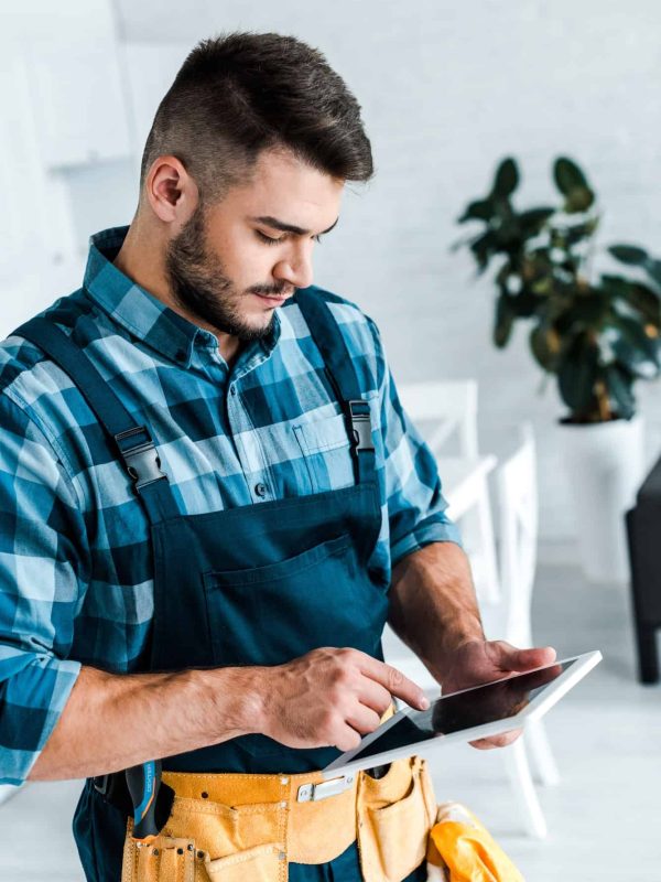 bearded handyman pointing with finger at digital tablet