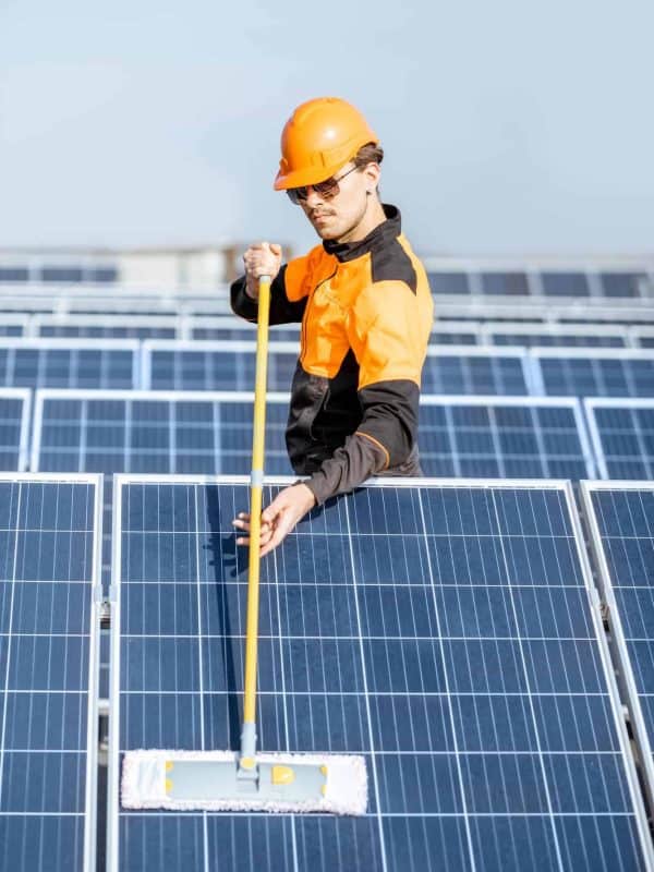 Workman cleaning solar panels