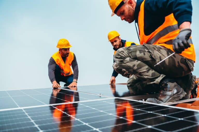 Workers assemble energy system with solar panel for electricity